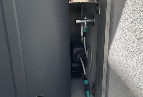 v mezeře  pod odkládací plochou na skleničku vína je uložen buben s hadicí na zalévání květin